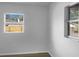 Well-lit bedroom with light grey walls, wood-look floors, and two windows providing natural light at 3305 Acapulco Dr, Riverview, FL 33578