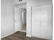 Bedroom showcasing closet doors and an open door to another room, complemented by light-colored walls and flooring at 3305 Acapulco Dr, Riverview, FL 33578