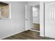 Bedroom showcasing closet doors and an open door to another room, complemented by light-colored walls and flooring at 3305 Acapulco Dr, Riverview, FL 33578