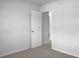 A hallway with an open door, neutral walls, and carpet flooring at 3305 Acapulco Dr, Riverview, FL 33578