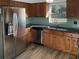 Modern kitchen featuring stainless steel appliances, wood cabinets, and sleek countertops with a green backsplash at 3305 Acapulco Dr, Riverview, FL 33578