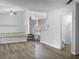 Open-concept living area featuring wood-look floors, white walls, and a staircase with white railings at 3305 Acapulco Dr, Riverview, FL 33578