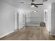 Open-concept living area featuring wood-look floors, white walls, and a staircase with white railings at 3305 Acapulco Dr, Riverview, FL 33578