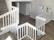 Bright staircase featuring carpeted steps and white banisters leading to a landing with wood-look flooring at 3305 Acapulco Dr, Riverview, FL 33578