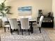 Stylish dining area with seating for six, beach themed art, and neutral decor at 3672 Lake Bayshore Dr # K327, Bradenton, FL 34205