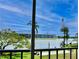Scenic lake view from the screened balcony with lush landscaping and building in the distance at 3672 Lake Bayshore Dr # K327, Bradenton, FL 34205
