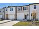 View of new townhomes with attached garages, modern exteriors, and manicured front yards at 6155 Calle Ochoa St, Zephyrhills, FL 33542