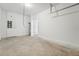 An empty garage interior with concrete floors, white walls, and visible utility connections at 6159 Calle Ochoa St, Zephyrhills, FL 33542