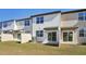 View of the back of the townhomes showing small, fenced backyards with sliding glass doors at 6167 Calle Ochoa St, Zephyrhills, FL 33542