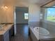 Modern bathroom featuring double sinks, tub, a glass shower and a window with a view at 25164 Calusa Dr, Punta Gorda, FL 33955