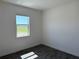 Bright bedroom with dark floors and a large window offering natural light and scenic views at 25164 Calusa Dr, Punta Gorda, FL 33955