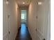Hallway featuring white walls, dark floors, and access to several rooms at 25164 Calusa Dr, Punta Gorda, FL 33955