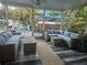 Spacious screened-in patio with comfortable wicker seating and dark-stained wood flooring at 424 N Carolina Ave, Palm Harbor, FL 34683