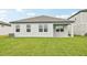 View of the backyard featuring a well maintained lawn, windows, and covered patio at 467 Sun Chaser Dr, Nokomis, FL 34275