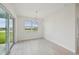 Bright dining area with a modern chandelier, large windows, and sliding glass doors to the backyard at 467 Sun Chaser Dr, Nokomis, FL 34275