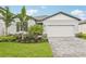 Charming single-story home with a two-car garage, manicured landscaping, and a welcoming paver driveway at 467 Sun Chaser Dr, Nokomis, FL 34275