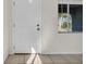 Bright foyer featuring neutral tile flooring, a white front door, and a view of the exterior through a window at 1616 39Th Avenue E Dr, Ellenton, FL 34222