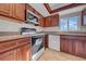 Kitchen with wood cabinets, white appliances, tile flooring, and natural light at 1618 39Th Avenue E Dr, Ellenton, FL 34222