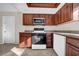 Kitchen featuring wood cabinetry, black oven, stainless steel microwave and white dishwasher at 1618 39Th Avenue E Dr, Ellenton, FL 34222