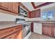 Kitchen featuring wood cabinetry, stainless steel microwave, and white appliances at 1618 39Th Avenue E Dr, Ellenton, FL 34222