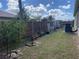 View of the backyard featuring a wooden fence, mature trees, and a cultivated garden area with potted plants at 23149 Hammond Ave, Port Charlotte, FL 33954
