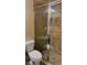 Bathroom featuring tiled shower with glass door, toilet, and storage shelves for amenities at 23149 Hammond Ave, Port Charlotte, FL 33954