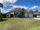 Desirable single Gathering home with a manicured lawn, mature palm trees and decorative wooden fence detail at 23149 Hammond Ave, Port Charlotte, FL 33954
