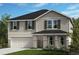 Charming two-story home with a manicured lawn, attached two-car garage, and decorative shutters at 6606 Tortoise Trl, Parrish, FL 34219