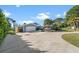 Attractive home exterior featuring a long driveway, a basketball hoop, and lush landscaping at 1690 Bayshore Dr, Englewood, FL 34223