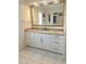 Bathroom vanity features granite countertop, white cabinetry, and a large mirror at 1706 S Lakeside Ct, Venice, FL 34293