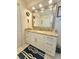 A bathroom featuring white cabinets, a large mirror, and granite countertops, offering a clean and modern look at 1706 S Lakeside Ct, Venice, FL 34293