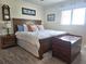 Spacious bedroom featuring a decorative wooden bedframe, bedside table, and a window providing natural light at 1706 S Lakeside Ct, Venice, FL 34293