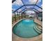 Screened pool area with brick pool with tile trim and lake view is perfect for enjoying the Florida sunshine at 1706 S Lakeside Ct, Venice, FL 34293