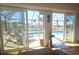 View from indoors through sliding glass doors to a swimming pool and an outdoor seating area at 1706 S Lakeside Ct, Venice, FL 34293