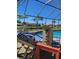 Relaxing by the pool area with comfortable lounge chairs, patio umbrella and scenic water view at 1706 S Lakeside Ct, Venice, FL 34293