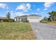 Inviting single-story home with manicured lawn, brick driveway, and a spacious three-car garage at 218 Soursop, Punta Gorda, FL 33955