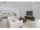 Open-concept living room with modern furniture, large windows, and seamless access to backyard at 218 Soursop, Punta Gorda, FL 33955
