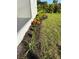 Side yard with landscaping featuring vibrant plants and rich mulch at 7343 N Ficus Tree, Punta Gorda, FL 33955