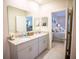 Well-lit bathroom featuring a double sink vanity with granite countertops and a view into the main bedroom at 11736 Linden Dr, Spring Hill, FL 34608