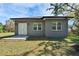 A modern home backyard featuring a well-manicured lawn, neutral color, and bright double door at 2324 Palm Ave, Seffner, FL 33584