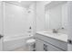 Bright bathroom featuring tiled shower over tub and gray vanity with white countertop at 1844 Draughton Dr, Zephyrhills, FL 33541