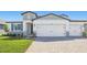 Beautiful two-story home featuring a three car garage and manicured lawn at 1844 Draughton Dr, Zephyrhills, FL 33541