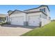 Exterior shot showcasing a three car garage with brick paver driveway at 1844 Draughton Dr, Zephyrhills, FL 33541