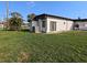 Expansive backyard view with lush green grass, tropical trees and home's exterior at 201 Ravenna N St, Nokomis, FL 34275