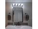 Bathroom features a modern vanity with a dark framed mirror and stylish lighting at 201 Ravenna N St, Nokomis, FL 34275