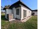 Exterior showing a well-maintained yard with French doors, and modern air conditioning unit at 201 Ravenna N St, Nokomis, FL 34275