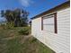 Outbuilding featuring a window and classic siding surrounded by lush greenery at 201 Ravenna N St, Nokomis, FL 34275