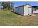 Exterior view of the storage shed with access ramp, near the main home and backyard lawn at 201 Ravenna N St, Nokomis, FL 34275
