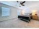 Well-lit bedroom featuring a ceiling fan, two windows, and comfortable furnishings at 36495 Garden Wall Way, Zephyrhills, FL 33541