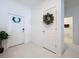 Bright entryway with white tile flooring and a decorative wreath on the interior door at 36495 Garden Wall Way, Zephyrhills, FL 33541